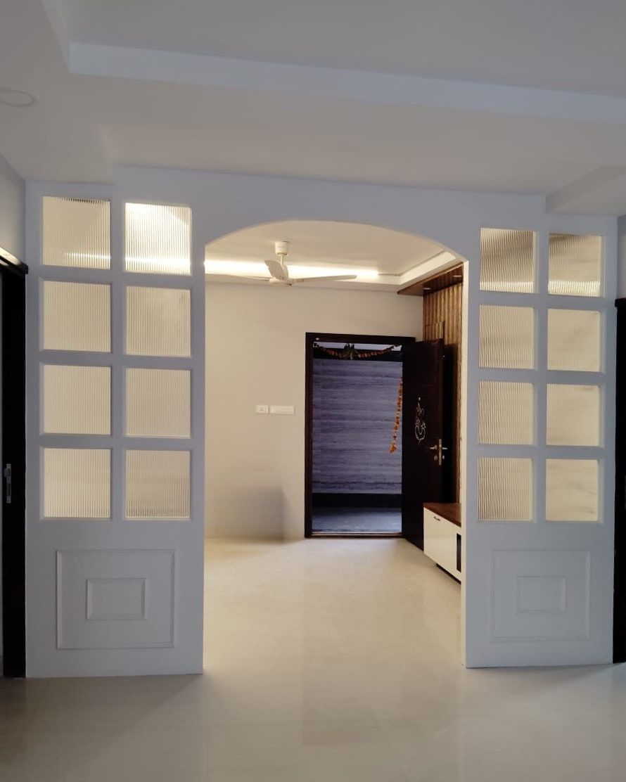 Arched opening flanked by white screens of reeded glass