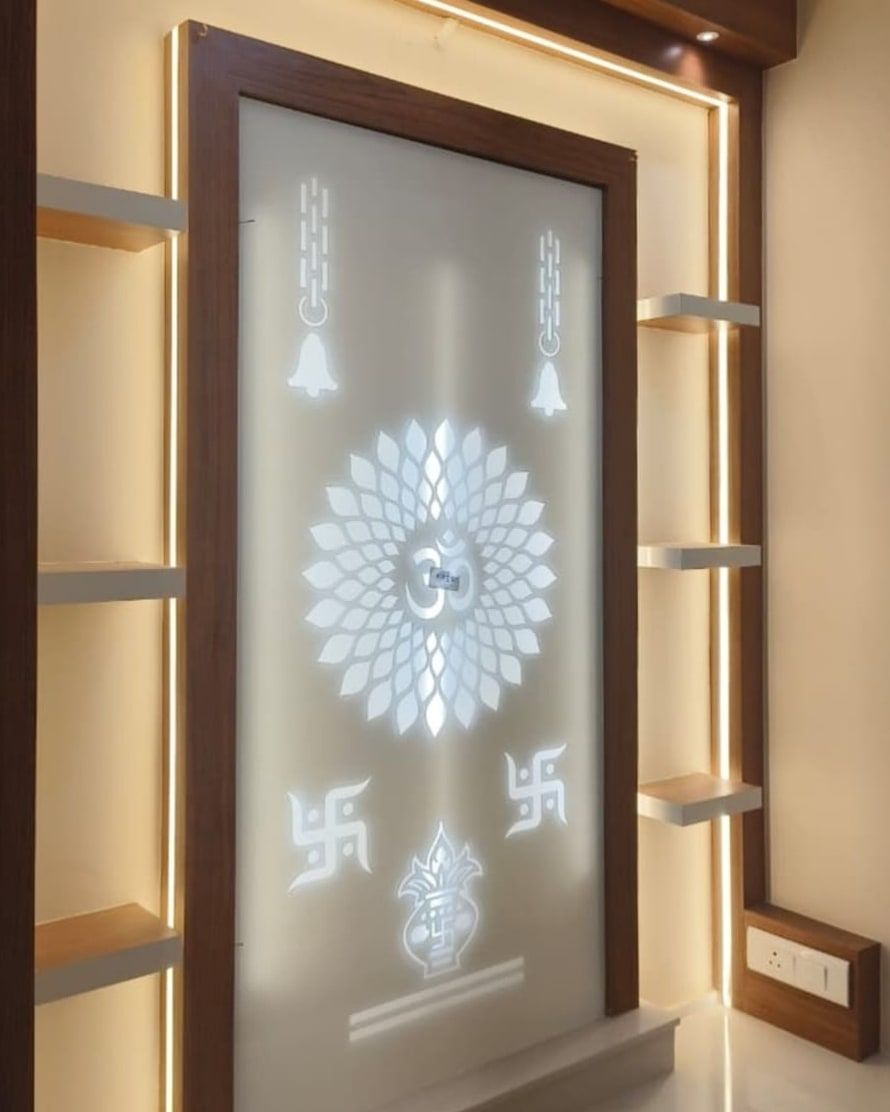 Backlit pooja panel with an etched om, bells and kalash, framed in wood between lit shelves