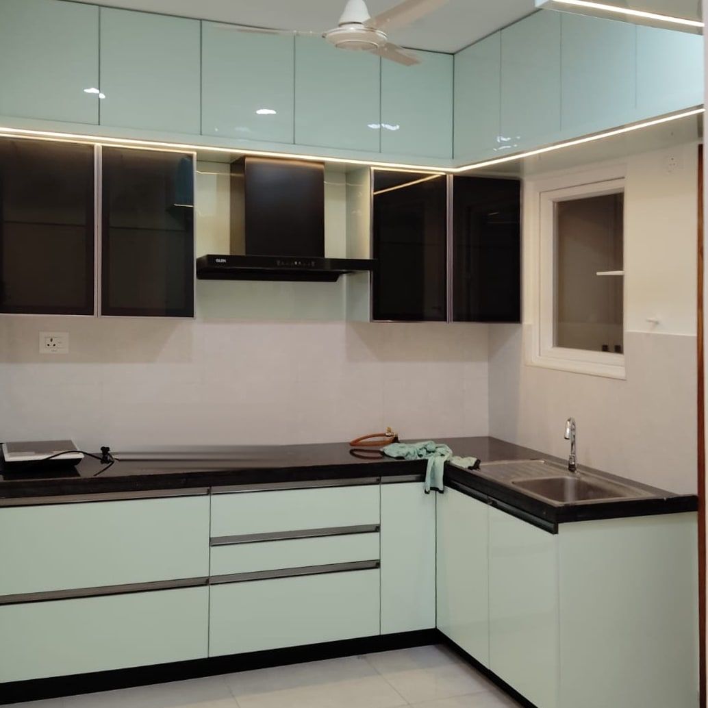 L-shaped kitchen with mint gloss shutters, dark glass uppers and a black counter